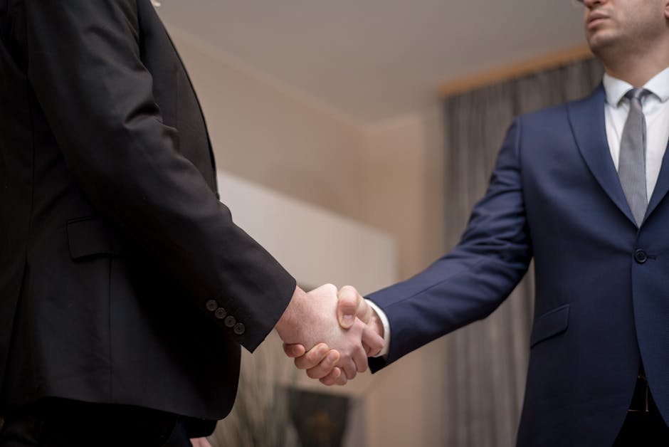 Studio legale Ciuffi,two lawyer in suits shaking hands, emphasizing trust and partnership indoors.